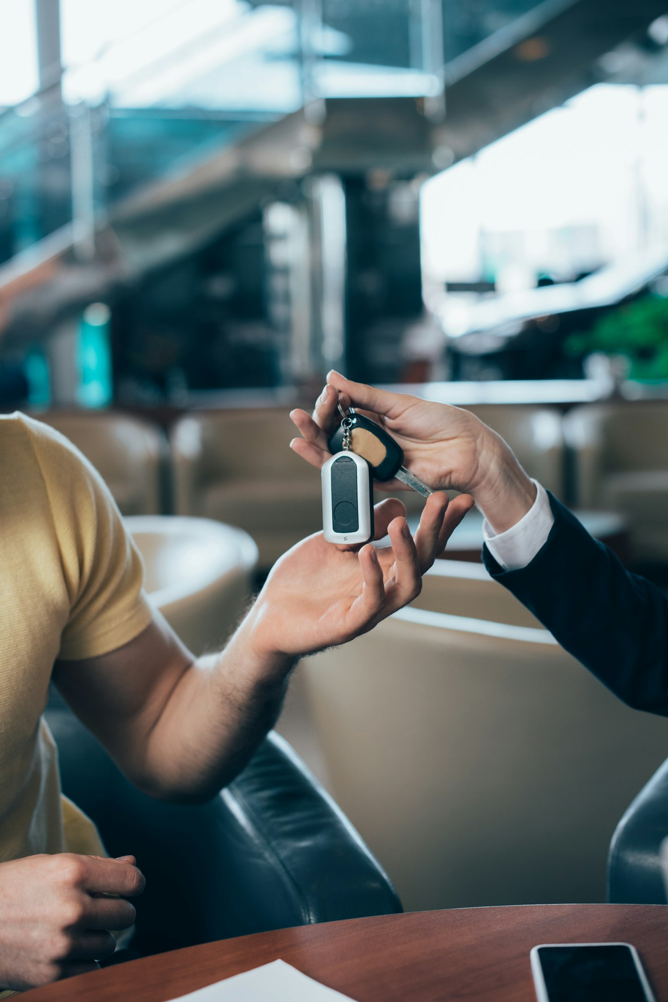 selective focus of car dealer giving car keys to customer