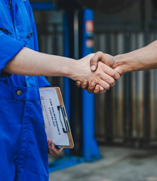 Auto mechanic handshake showing success collaboration of mechanics Check and maintain the engine for