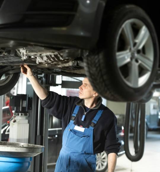 Mechanic in uniform is working in auto service