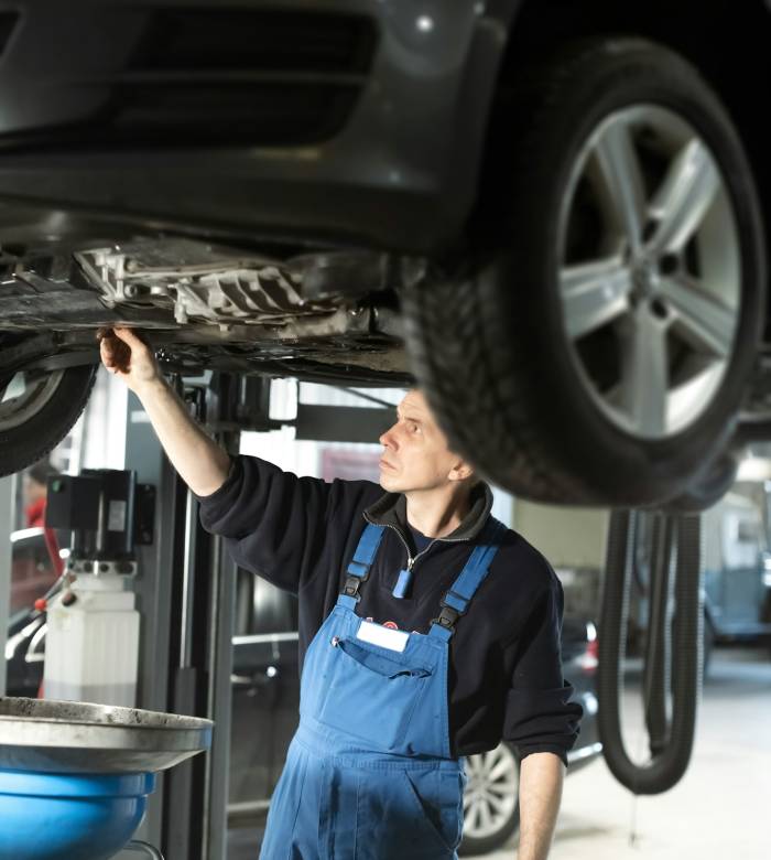 Mechanic in uniform is working in auto service