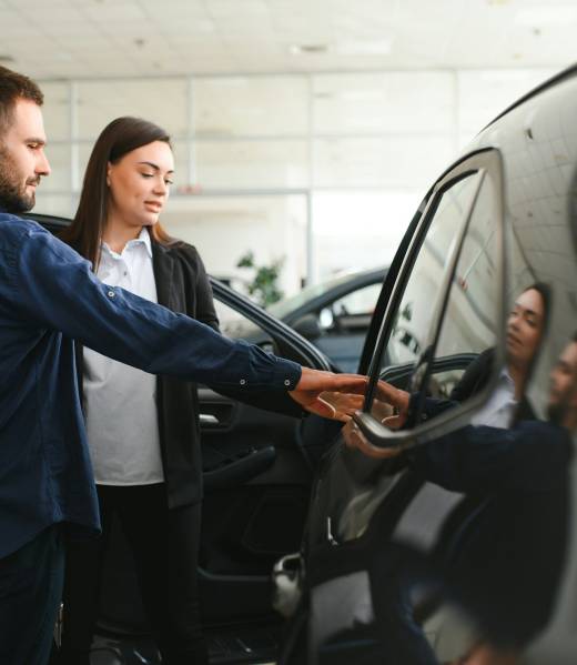 Salesperson selling cars at car dealership